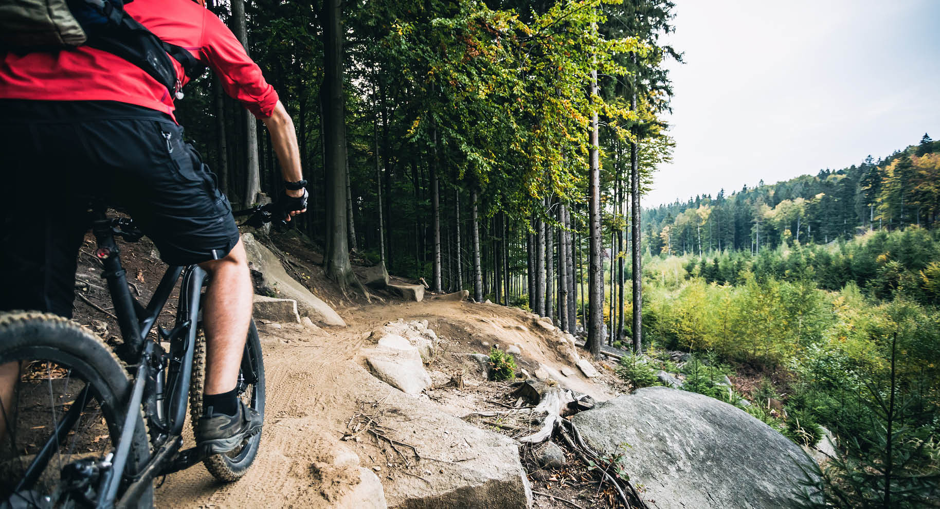 Mountain biker riding on bike in autumn inspirational mountains landscape. Man cycling MTB on enduro trail track. Sport fitness motivation and inspiration.