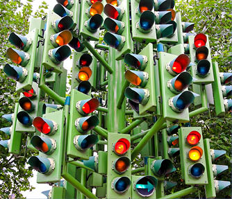 Lot of traffic lights at big pole.