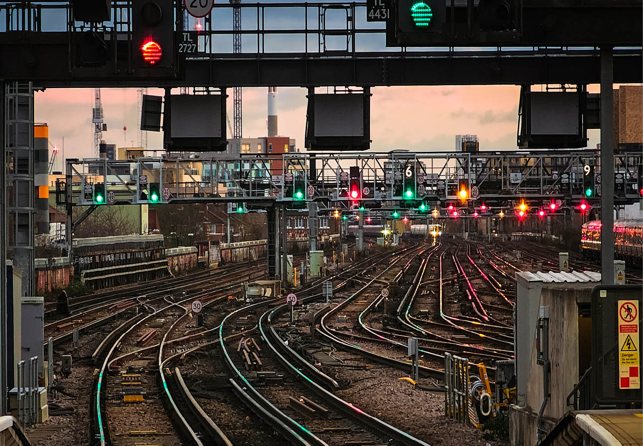 Interconnecting railroad tracks illuminated at dusk at London Bridge railroad station.